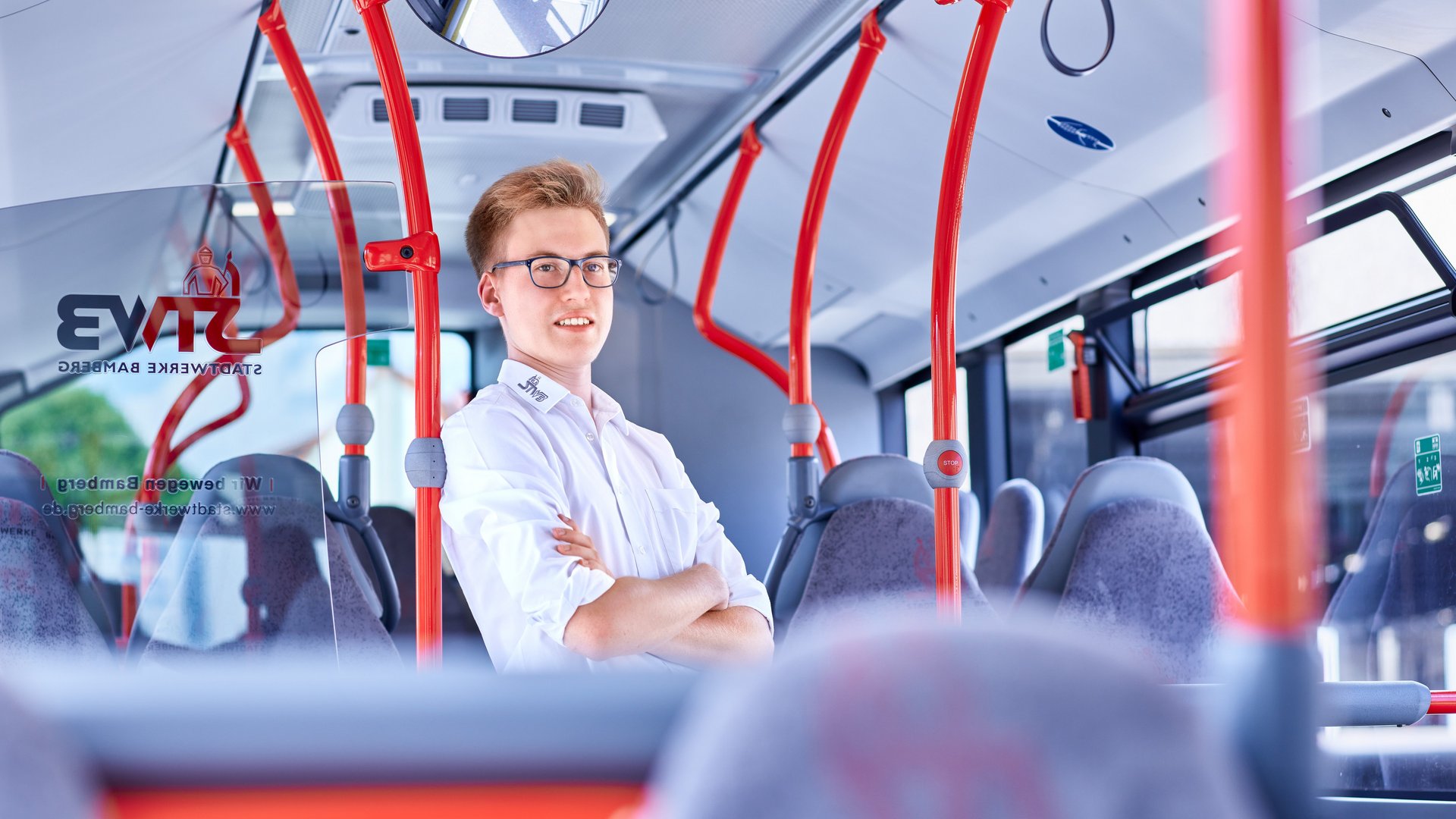 Junger Busfahrer im Fahrgastraum Junger Busfahrer im Fahrgastraum