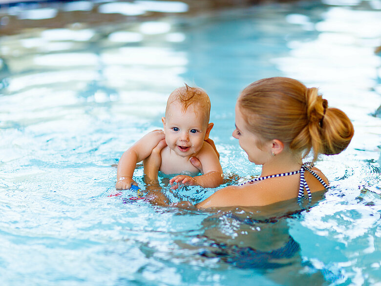 Frau mit Baby im Wasser