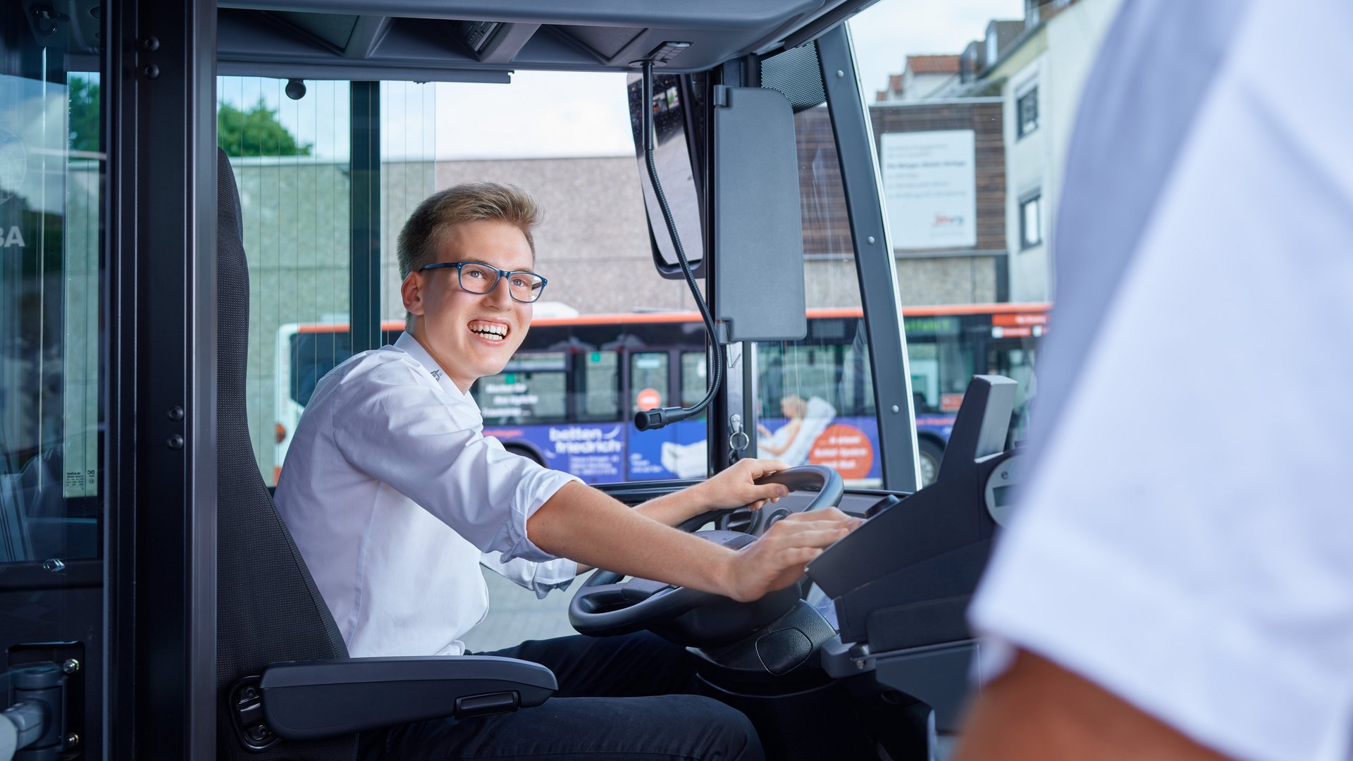 Junger Busfahrer am Fahrersitz Junger Busfahrer am Fahrersitz