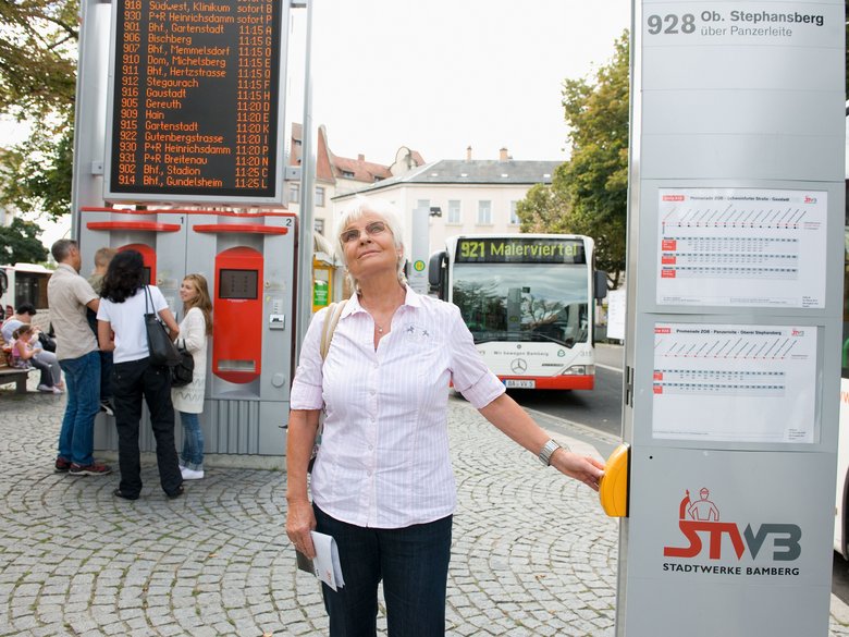 Seniorin lässt sich die Haltestelle am ZOB vorlesen